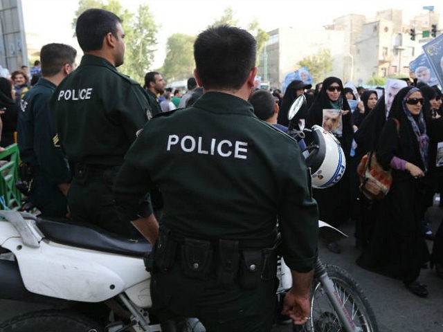 Iranian police watch as female supporters of Iranian presidential candidate and lead nucle
