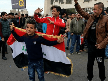 People celebrate as they wave national flags in Tahrir Square, Baghdad, Iraq, Sunday, Dec. 10, 2017. Iraqi Prime Minister Haider al-Abadi formally announced the victory of the military over IS forces, in an address to the nation aired on Iraqi state television Saturday evening. (AP Photo/Karim Kadim)