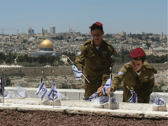 Israeli soldiers place flags on the graves of Jews killed in the battle for Jerusalem duri