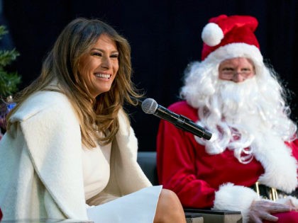 First lady Melania Trump, accompanied by Santa Claus, smiles as she takes questions from c