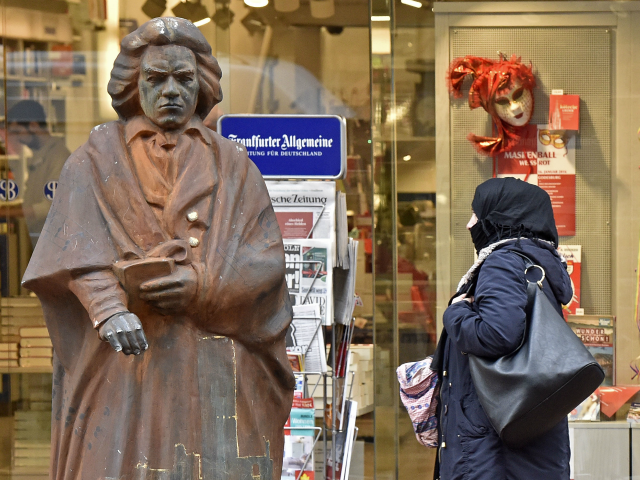 A covered Muslim woman passes a statue of composer Ludwig van Beethoven in the city of Bon