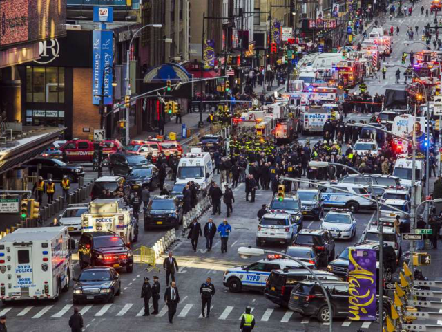 Law enforcement officials work following an explosion near New York's Times Square on Mond