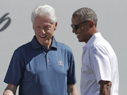 Former Presidents Barack Obama, right, and Bill Clinton greet U.S. team members before the first round of the Presidents Cup at Liberty National Golf Club in Jersey City, N.J., Thursday, Sept. 28, 2017. (AP Photo/Julio Cortez)
