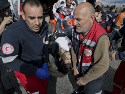 Palestinian paramedics evacuate a wounded protester who wears what looks like a suicide belt during clashes with Israeli troops following protests against U.S. President Donald Trump's decision to recognize Jerusalem as the capital of Israel, in the West Bank city of Ramallah, Friday, Dec. 15, 2017. The man was shot …