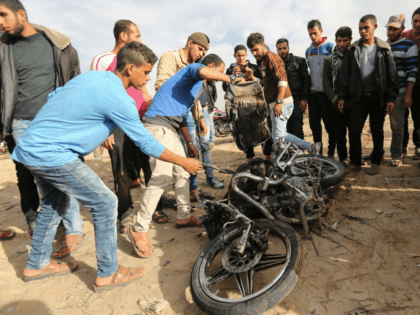 Palestinians inspect the damaged remains of a motorcycle, that was reportedly hit by an Israeli strike according to the Palestinian health ministry spokesman, in Beit Lahia in the northern Gaza Strip on December 12, 2017. Two Palestinians were killed in the Gaza Strip with authorities in the Hamas-run territory blaming …