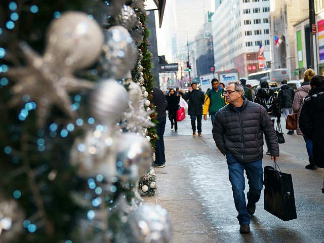 NEW YORK, NY - DECEMBER 18: A man carrying a shopping bag walks past holiday decorations along Fifth Avenue in Midtown Manhattan, December 18, 2017 in New York City. The city is decked out in holiday spirit with Christmas one week away from today. (Photo by Drew Angerer/Getty Images)