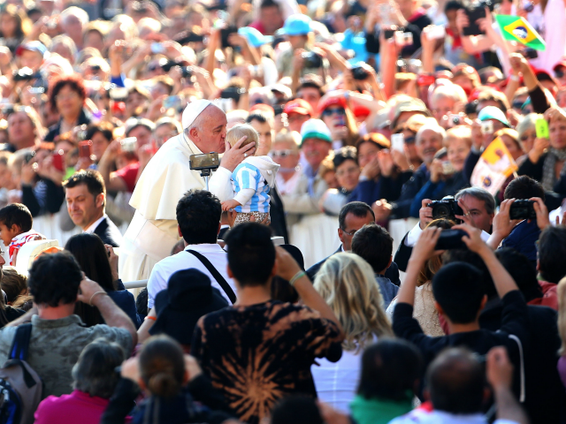 VATICAN CITY, VATICAN - OCTOBER 08: Pope Francis kisses a child as he arrives in St. Peter's square for his weekly public audience on October 8, 2014 in Vatican City, Vatican. Speaking to the crowds gathered in St. Peter's Square for the weekly General Audience Pope Francis appealed for Christian …
