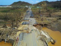 road-washed-away-hurricane-maria-puerto-rico-2017-getty A man rides his bicycle through a damaged road in Toa Alta, west of San Juan, Puerto Rico, on September 24, 2017 following the passage of Hurricane Maria. / AFP PHOTO / Ricardo ARDUENGO (Photo credit should read RICARDO ARDUENGO/AFP/Getty Images)