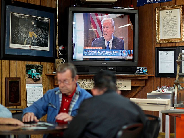A newscast showing President Donald Trump plays on an old television set as customers play
