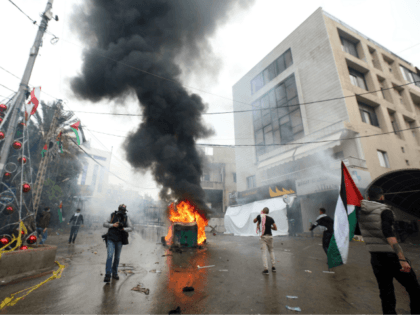 Lebanese security forces fire tear gas to disperse protestors as a fire burns in a dumpster during a demonstration outside the US embassy in Awkar, on the outskirts of the Lebanese capital Beirut, on December 10, 2017, to protest against Washington's decision to recognise Jerusalem as the capital of Israel. …