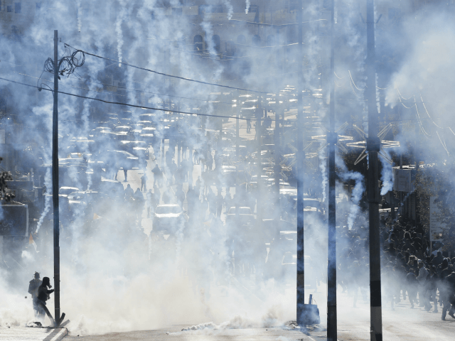 Israeli troops fire teargas towards Palestinians during a protest against U.S. President D