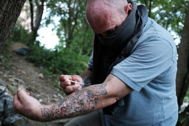 Chris, a homeless heroin addict pictured in this July 31, 2017 file photo, shoots up by a
