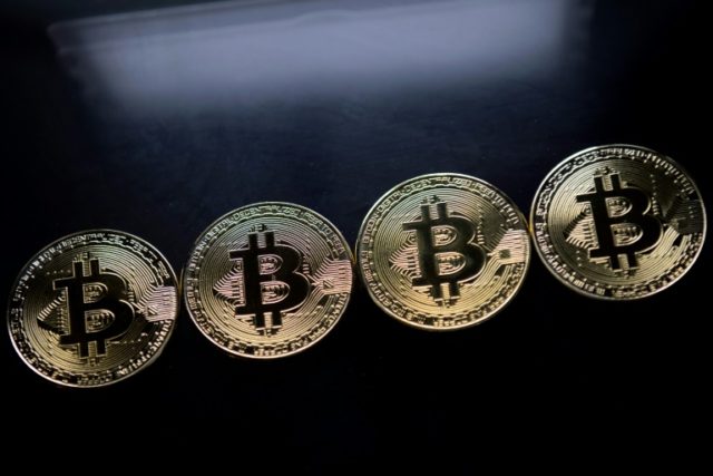 This file photo shows gold plated souvenir Bitcoin coins, as the digital currency makes it