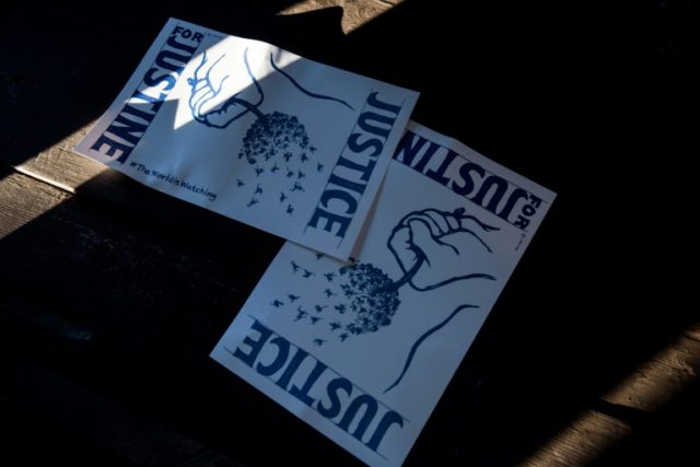 Signs reading "Justice for Justine" lie on a park table during a demonstration in Minneapo