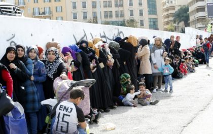 Syrian refugees queue to receive aid in Beirut's Martyrs Square on November 26, 2017, as part of the "Dafa" campaign aimed at helping Syrian refugees and Lebanese families in need