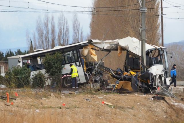 The wreckage of a school bus after it was hit by a train at a level crossing in the villag