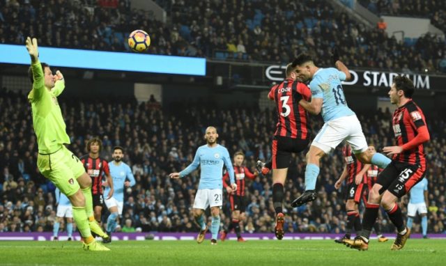 Manchester City's striker Sergio Aguero (R) heads the ball to score their third goal again