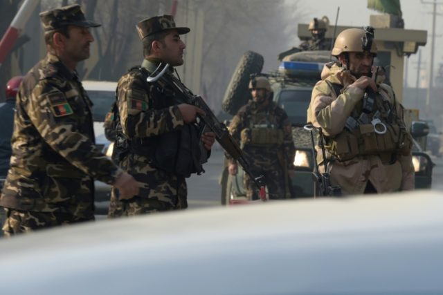 Afghan security personnel block a road near the site of a suicide attack close to an intel