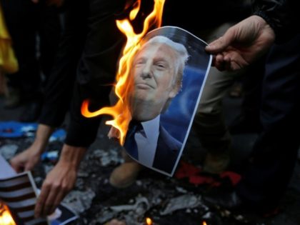 Iranian demonstrators burn a portrait of US President Donald Trump during a protest in Teh