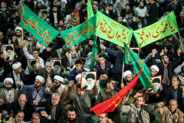 Iranians chant slogans as they march in support of the regime near the Imam Khomeini grand mosque in Tehran on December 30, 2017
