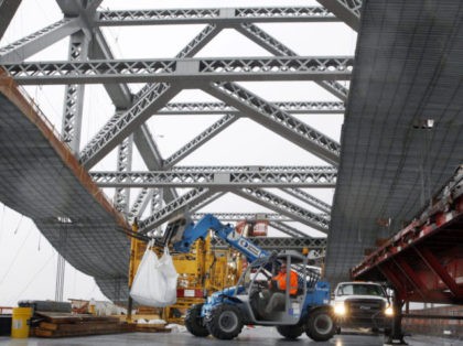 FILE - In this Nov. 15, 2016, file photo, a worker lifts materials as construction continu