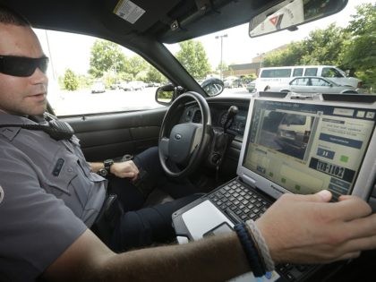 FILE- In this July 16, 2013, file photo, Officer Dennis Vafier, of the Alexandria Police Department, uses a laptop in his squad car to scan vehicle license plates during his patrols in Alexandria, Va. It would violate people's privacy to publicly release raw data collected by automated license plate readers …