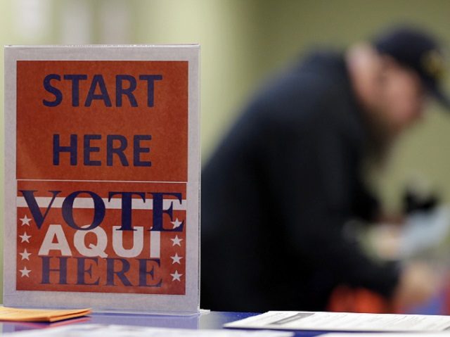 In this Wednesday, Feb. 26, 2014 photo, a voter prepares to cast his ballot at an early voting polling site, in Austin, Texas. In elections that begin next week, voters in 10 states will be required to present photo identification before casting ballots _ the first major test of voter …