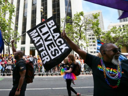 Men wave rainbow and 'black lives matter' flags while marching in the annual LGBTQI Pride Parade on Sunday, June 25, 2017 in San Francisco, California. The LGBT community descended on Market Street for the 47th annual Pride Parade. (Photo by Elijah Nouvelage/Getty Images)