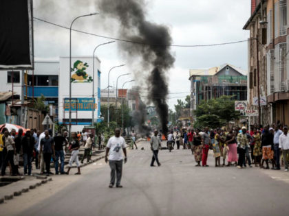 People look on as protesters burn tyres during a demonstration calling for the President of the Democratic Republic of the Congo to step down on January 21, 2018 in Kinshasa.