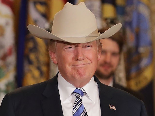 WASHINGTON, DC - JULY 17: U.S. President Donald Trump wears a Stetson cowboy hat given to him by Dustin Noblitt (L) while touring a Made in America product showcase in the East Room of the White House July 17, 2017 in Washington, DC. American manufacturers representing each of the 50 …