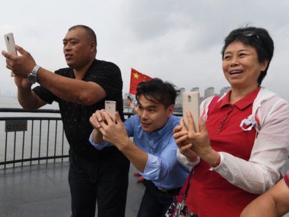 Chinese tourists take photos of North Korea from the Broken Bridge at the Chinese border c