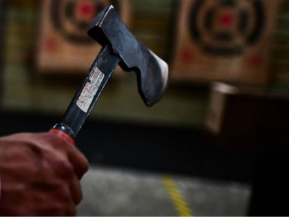 A man aims a hatchet at his target as he plays hatchet throwing at the Stumpy's House