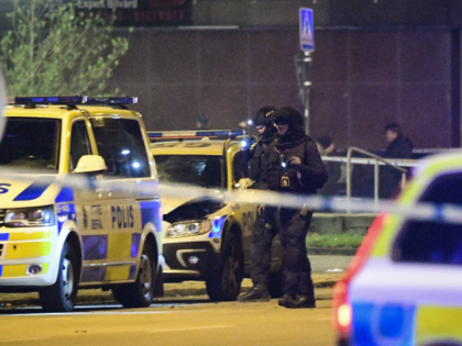 Police officers check a police car, parked outside a police station, that was said to be d