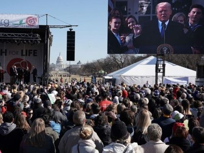 WASHINGTON, DC - JANUARY 19: Pro-life activists watch U.S. President Donald Trump giving r