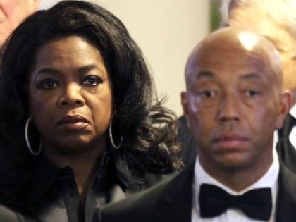Oprah Winfrey, center, stands with Russell Simmons, right, and other mourners as the casket enters for the funeral of Eunice Kennedy Shriver at Saint Francis Xavier Roman Catholic Church in the Hyannis section of Barnstable, Mass., Friday, Aug. 14, 2009. Shriver, the sister of President John F. Kennedy and Massachusetts …