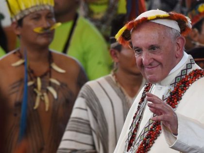 TOPSHOT - Pope Francis, wearing gifts, leaves after a meeting with representatives of indigenous communities of the Amazon basin from Peru, Brazil and Bolivia, in the Peruvian city of Puerto Maldonado, on January 19, 2018. Pope Francis sounded a stark warning about the future of the Amazon and its peoples …