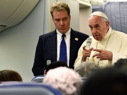 Pope Francis answers journalists flanked by the director of the Vatican press office Greg