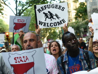 Protestors hold placards during a demonstration in a Barcelona on June 19, 2016 under the slogan, 'open borders, we welcome' in favour of rights for refugees and demanding that European authorities take action to secure safe passage routes for refugees. / AFP / JOSEP LAGO (Photo credit should read JOSEP …
