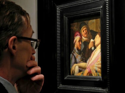 A visitor to the booth of Galerie Talabardon & Gautier at the TEFAF fine art fair looks at a newly discovered painting by Dutch master Rembrandt titled The Unconscious Patient (Sense of Smell) dated at around 1624-25, oil on panel 21.6x17.8 cm, in Maastricht, southern Netherlands, Thursday, March 10, 2016. …