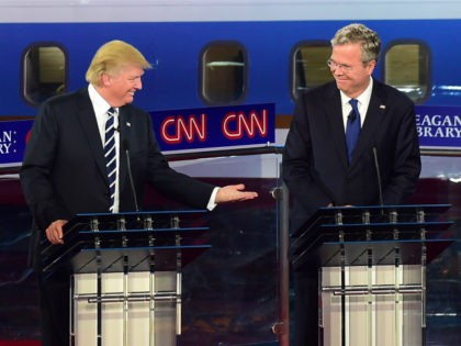 Republican presidential hopefuls, real estate magnate Donald Trump gestures toward former