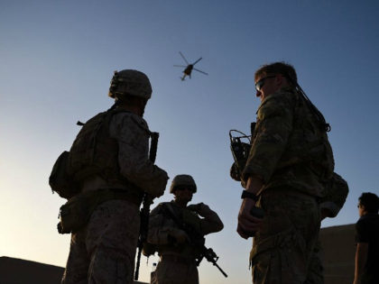 In this photograph taken on August 27, 2017 US Marines and Afghan Commandos stand together as an Afghan Air Force helicopter flies past during a combat training exercise at Shorab Military Camp in Lashkar Gah in Helmand province. Marines in Afghanistan's Helmand say Donald Trump's decision to keep boots on …