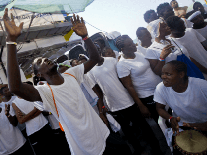 African migrants sing and dance on the deck of the Aquarius vessel of "SOS Mediterranee" a