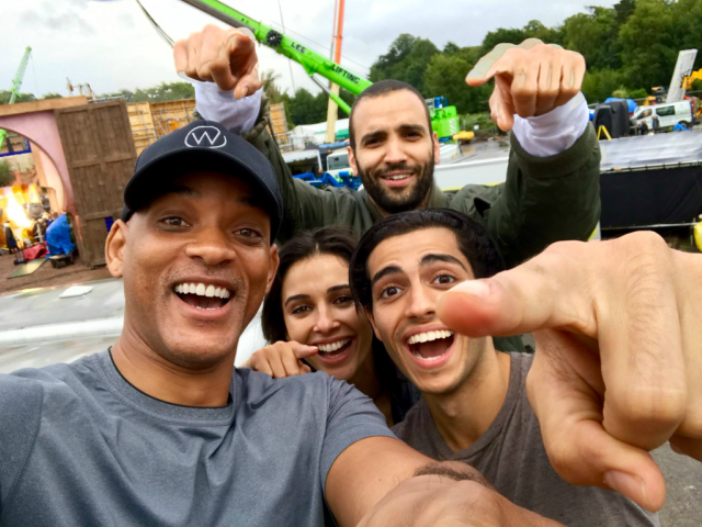 We just started shooting Aladdin and I wanted to intro you guys to our new family… Mena Massoud/Aladdin, Naomi Scott/Princess Jasmine, Marwan Kenzari/Jafar, and I’m over here gettin my Genie on. Here we go! — with Naomi Scott and Mena Massoud.