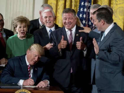 FILE - In this June 5, 2017, file photoRep. Bill Shuster, R-Pa., center, gives two thumbs up as he gets two autographs from President Donald Trump after Trump signs a decision memo and a letter to members of Congress outlining the principles of his plan to privatize the nation's air …