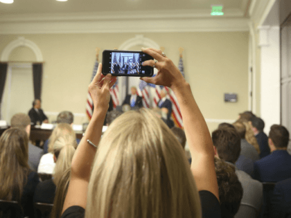 A White House staff members uses her cellphone to record President Donald Trump speaking at a meeting of the Presidential Advisory Commission on Election Integrity, Wednesday, July 19, 2017, in the Eisenhower Executive Office Building on the White House complex in Washington. (AP Photo/Pablo Martinez Monsivais)