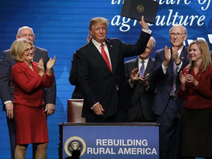 President Donald Trump acknowledges applause after signing an executive order at the American Farm Bureau Federation annual convention Monday, Jan. 8, 2018, in Nashville, Tenn. (AP Photo/Mark Humphrey)
