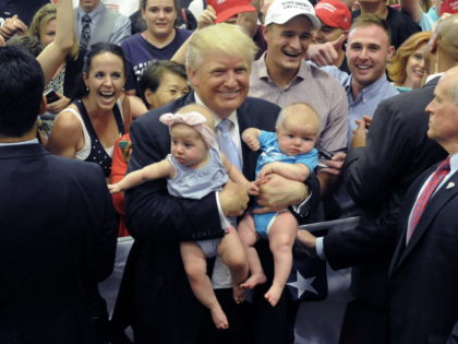 US Republican Presidential Candidate Donald Trump holds two babies after his Town Hall add