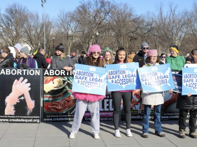 Women's March participants held pro-abortion signs to block images of aborted babies. One