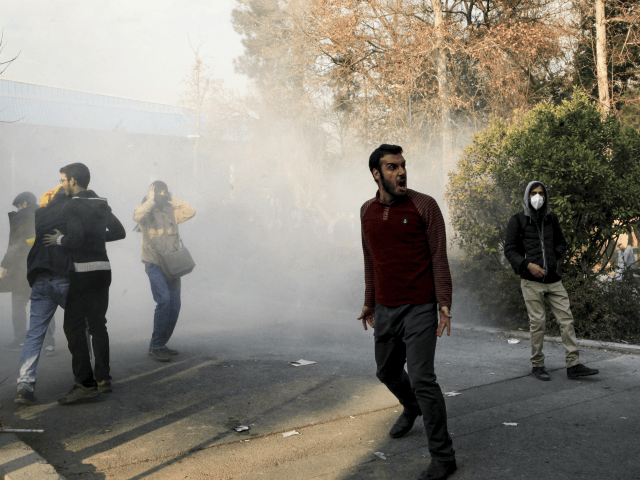 In this photo taken by an individual not employed by the Associated Press and obtained by the AP outside Iran, university students attend a protest inside Tehran University while a smoke grenade is thrown by anti-riot Iranian police, in Tehran, Iran, Saturday, Dec. 30, 2017. A wave of spontaneous protests …