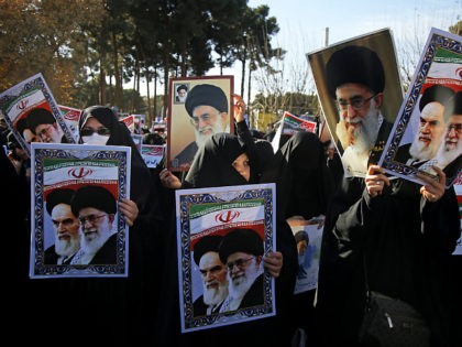 In this photo provided by Tasnim News Agency, women hold posters showing portraits of late Iranian revolutionary founder Ayatollah Khomeini, and Supreme Leader Ayatollah Ali Khamenei during a pro-government rally in the holy city of Qom, Iran, Wednesday, Jan. 3, 2018. Tens of thousands of Iranians took part in pro-government …